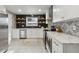 Modern kitchen features stainless steel appliances, black backsplash and floating wood shelves, with white cabinets and countertops at 9962 W 77Th Ave, Arvada, CO 80005