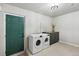 Laundry room with washer, dryer, and green door at 9962 W 77Th Ave, Arvada, CO 80005