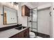 A modern bathroom featuring textured walls, a sleek black sink, a walk-in shower, and stylish wooden cabinets at 7219 S Brook Forest Rd, Evergreen, CO 80439