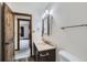 Bathroom featuring a marble sink and countertop, a mirror, and a doorway leading into a carpeted room at 7219 S Brook Forest Rd, Evergreen, CO 80439