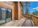 Spacious outdoor deck with wood railings and a sliding glass door offers stunning views of the surrounding landscape at 7219 S Brook Forest Rd, Evergreen, CO 80439