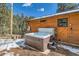 Relaxing hot tub located on the wood exterior of the home with snowy landscaping at 7219 S Brook Forest Rd, Evergreen, CO 80439