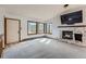 Bright living room with a stone fireplace and large windows showcasing the natural surroundings at 7219 S Brook Forest Rd, Evergreen, CO 80439