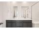 Well-lit bathroom featuring double sinks, large mirrors, and a glass-enclosed shower at 2150 S Haleyville Way, Aurora, CO 80018