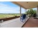 Inviting covered back porch with rocking chairs overlooks scenic views at 6618 Lynch Ln, Castle Rock, CO 80108