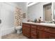 Bright bathroom featuring a double sink vanity and shower with tub and floral curtain at 6618 Lynch Ln, Castle Rock, CO 80108