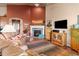 Cozy living room with a fireplace, comfortable leather furniture, and wood floors at 6618 Lynch Ln, Castle Rock, CO 80108