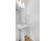 Modern half-bathroom with pedestal sink, mirror and hardwood floors at 1175 Highview Dr, Erie, CO 80516
