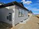 New home displays gray siding and window wells along the side of the house at 17136 W 92Nd Loop, Arvada, CO 80007