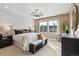 Serene main bedroom with a patterned accent wall, large windows, and a comfortable bed at 17136 W 92Nd Loop, Arvada, CO 80007