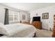 The spacious bedroom features a plush bed and a dresser, bathed in soft natural light streaming through the blinds at 4635 S Odessa St, Centennial, CO 80015