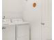 Bright laundry area features a white washer and dryer, complementing the neutral walls and door at 4635 S Odessa St, Centennial, CO 80015