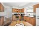 Well-lit kitchen featuring wooden cabinets, stainless steel appliances, and a dining area at 5351 S Cody St, Littleton, CO 80123
