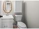 Cozy powder room featuring a white vanity, decorative mirror, and toilet at 7101 W Yale Ave # 3403, Denver, CO 80227