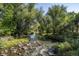 The stream behind this property has mature trees that provide shade to the green grass at 7101 W Yale Ave # 3403, Denver, CO 80227