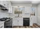 Well-lit kitchen features white cabinets and black appliances at 7101 W Yale Ave # 3403, Denver, CO 80227