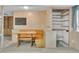 Inviting basement area with a built-in dining nook, open shelving, and stylish wood paneling at 5960 S Estes St, Littleton, CO 80123
