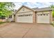 A home's exterior is defined by its brick accents and a two-car garage, with a concrete driveway at 5960 S Estes St, Littleton, CO 80123