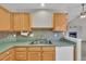 A bright kitchen featuring light wood cabinets, stainless steel appliances, and an undermount sink at 5960 S Estes St, Littleton, CO 80123