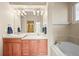 Bright bathroom featuring dual sinks, a soaking tub, and modern fixtures at 23961 E Easter Pl, Aurora, CO 80016