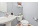 Powder room with modern pedestal sink, toilet, and light blue paint at 23961 E Easter Pl, Aurora, CO 80016