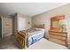 Comfortable bedroom featuring a full bed frame, a dresser with a lamp, and neutral carpeting at 23961 E Easter Pl, Aurora, CO 80016
