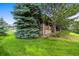 Stone and wood exterior of home with mature landscaping and lush green grass at 23961 E Easter Pl, Aurora, CO 80016