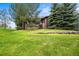 Well-manicured lawn with trees in front of the house, offering privacy and curb appeal at 23961 E Easter Pl, Aurora, CO 80016