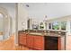 Open kitchen with granite countertops, wood cabinets, and adjacent living area with fireplace at 23961 E Easter Pl, Aurora, CO 80016