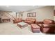 Spacious living room with plush seating, a decorative coffee table, and neutral carpeting at 23961 E Easter Pl, Aurora, CO 80016