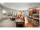 Sunlit living area with hardwood floors, comfortable seating, an adjacent kitchen, and picturesque views at 23961 E Easter Pl, Aurora, CO 80016