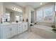 Spa-like bathroom with double sinks, a large soaking tub, and a separate shower at 5199 S Fairplay St, Aurora, CO 80015