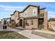 Two-story townhome with brick and siding exterior, a bench, and a small yard at 5199 S Fairplay St, Aurora, CO 80015