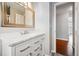 Bathroom vanity with marble countertop and chrome hardware, next to doorway at 14793 E Hampden Pl, Aurora, CO 80014