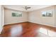 Empty bedroom featuring hardwood floors, ceiling fan, and bright windows at 14793 E Hampden Pl, Aurora, CO 80014