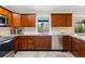 Kitchen features stainless appliances, granite counters, and warm wood cabinets at 14793 E Hampden Pl, Aurora, CO 80014