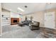Cozy living room with a brick fireplace, built-in bookshelves, and neutral carpeting at 14793 E Hampden Pl, Aurora, CO 80014