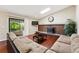 Bright living room with brick fireplace, hardwood floors, comfortable sectional, and sliding door to outdoor space at 14793 E Hampden Pl, Aurora, CO 80014
