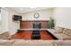 Bright living room features a brick fireplace, hardwood floors, a skylight, and a large comfortable sectional at 14793 E Hampden Pl, Aurora, CO 80014