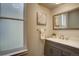 Bathroom features a window, gray vanity, white sink and countertop, and a decorative mirror at 124 Elati St, Denver, CO 80223