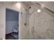 Elegant bathroom featuring tiled walk-in shower with glass door and a view of the sitting area at 124 Elati St, Denver, CO 80223