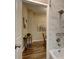 Bathroom with tub-shower combo, marble tile, and a view into an adjacent room with wood floors at 124 Elati St, Denver, CO 80223