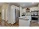 Modern kitchen featuring white cabinets, stainless steel appliances, and an island with a granite countertop at 124 Elati St, Denver, CO 80223