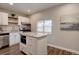 Bright kitchen featuring white cabinets, stainless steel appliances, and an island with a granite countertop at 124 Elati St, Denver, CO 80223