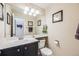 Small bathroom with dark vanity, toilet, and mirror at 13942 Jackson St, Thornton, CO 80602