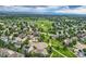 Expansive aerial view of a community with lush green spaces, walking paths, and mountain views in the distance at 7866 Witney Pl, Lone Tree, CO 80124