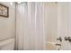 Bright bathroom featuring a shower-tub combination with tiled walls and a shower curtain at 7866 Witney Pl, Lone Tree, CO 80124