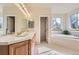 Bright bathroom featuring dual sinks, spacious vanity, tile floor and a soaking tub for ultimate relaxation at 7866 Witney Pl, Lone Tree, CO 80124