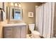 Stylish bathroom featuring gray vanity with marble countertop, framed mirror and shower with patterned curtain at 7866 Witney Pl, Lone Tree, CO 80124