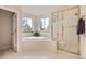 Relaxing bathroom with garden tub, glass shower, tile floors, and large windows offering natural light and a view at 7866 Witney Pl, Lone Tree, CO 80124